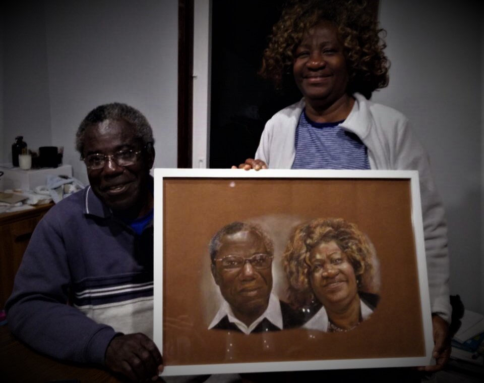 Portrait commission of african couple holding their pastel portrait